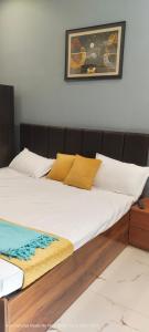 a large bed with white sheets and yellow pillows at HOTEL AYODHYA PAYING GUEST in Ayodhya