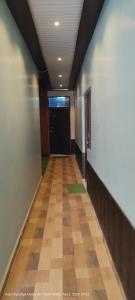 a hallway with a black door and a wooden floor at HOTEL AYODHYA PAYING GUEST in Ayodhya