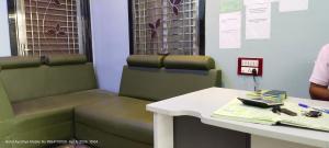 a waiting room with green chairs and a table at HOTEL AYODHYA PAYING GUEST in Ayodhya