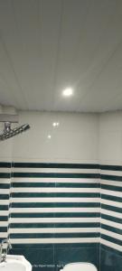a bathroom with two toilets and a wall with stripes at HOTEL AYODHYA PAYING GUEST in Ayodhya