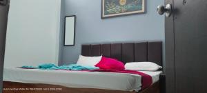 a bed with pink and blue pillows on it at HOTEL AYODHYA PAYING GUEST in Ayodhya