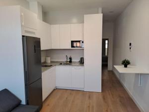 a white kitchen with white cabinets and a wooden floor at Nidito Sandua in Pamplona