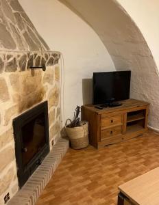 a living room with a fireplace and a television at Casa rural in Puebla de Don Fadrique +9 photos