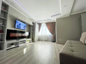 salon z kanapą i telewizorem z płaskim ekranem w obiekcie Brand New Apartment Main Road w Kiszyniowie