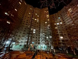 um grande edifício de apartamentos à noite com luzes em Brand New Apartment Main Road em Chisinau