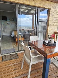 a patio with a table and chairs on a deck at Bliss on JBay - Blissful in Jeffreys Bay