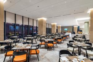 a restaurant with tables and chairs in a room at Awaken Da Nang Hotel in Danang