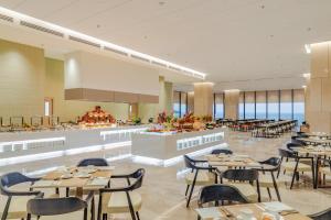 a restaurant with tables and chairs and a cafeteria at Awaken Da Nang Hotel in Danang