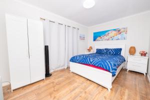 a white bedroom with a bed and a dresser at 29 in Corio