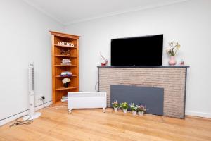 a living room with a tv on a brick fireplace at 29 in Corio