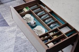 a wooden drawer with cups and dishes in it at ANA InterContinental Tokyo by IHG in Tokyo