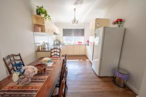 a kitchen with a table and a refrigerator at Classic decor, freshly painted 3 by 2 quiet home in Corio