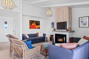 a living room with blue couches and a fireplace at Lakefront Style - Lake Taupo Holiday Home in Taupo