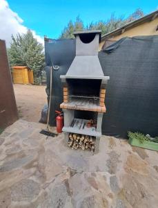 a outdoor grill sitting on top of a patio at Cabaña del olivo in Paredes de Buitrago
