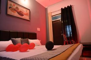 a bedroom with a bed with red pillows on it at HOTEL AYODHYA PAYING GUEST in Ayodhya