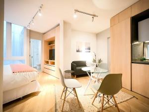 1 dormitorio con 1 cama, mesa y sillas en LOFT ubicado en el corazón de Santiago, Lastarria, en Santiago