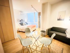 a living room with a couch and a table and chairs at LOFT ubicado en el corazón de Santiago, Lastarria in Santiago