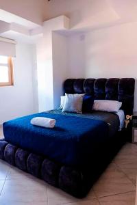 ein großes Bett in einem Zimmer mit einem großen Kopfteil in der Unterkunft Apartamento 402 - Terraza con Jacuzzi - 3 Habitaciones - Rentas Cortas Gerencial in Guatapé
