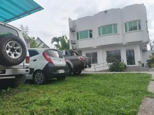 dos autos estacionados en un patio frente a una casa en Sillero Painting Gallery and Hostel, en Dumaguete