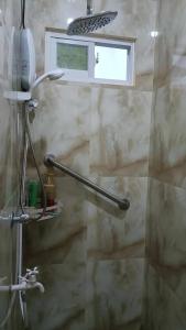 y baño con ducha y ventana. en Sillero Painting Gallery and Hostel en Dumaguete