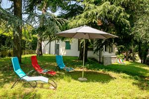 trzy krzesła i parasol przed domem w obiekcie Villa Alberti Appartamento Emma - Happy Rentals w mieście Salò