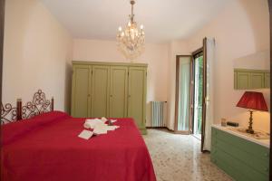 sypialnia z czerwonym łóżkiem i żyrandolem w obiekcie Villa Alberti Appartamento Emma - Happy Rentals w mieście Salò