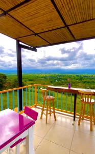 balcón con mesa, sillas y vistas al océano en Finca Hotel Mirador La Casona Quindio-Eje Cafetero, en Pueblo Tapado