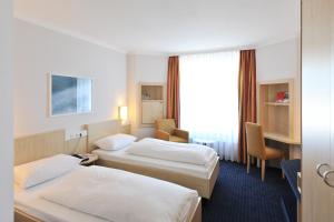 Ein Bett oder Betten in einem Zimmer der Unterkunft IntercityHotel Kiel