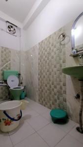 uma casa de banho com um WC verde e um lavatório em DWARIKA HOTEL em Dwārāhāt