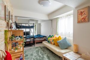 LANDMARK NAMBA EBISUCHO chan في أوساكا: غرفة معيشة مع أريكة وسرير بطابقين