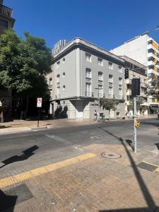 uma rua da cidade vazia com um grande edifício branco em Acogedor y Luminoso Studio en Monjitas ServicioHOM em Santiago