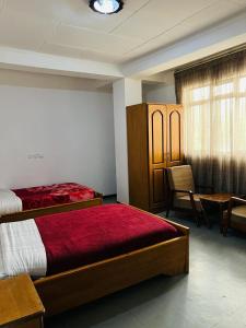 Goza Guest House 22 في أديس أبابا: غرفة نوم بسريرين وطاولة وكراسي