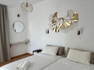 um quarto com duas camas e um relógio na parede em Nikos studios em Livadia