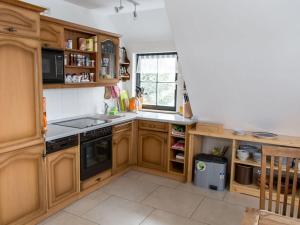 een keuken met houten kasten en een fornuis met oven bij Holiday home Zinnwald large in Kurort Altenberg