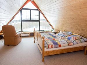 een slaapkamer met een bed en een stoel in een kamer bij Holiday home Zinnwald large in Kurort Altenberg