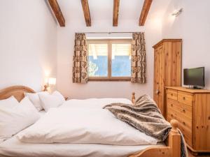 a bedroom with a white bed and a window at BergChalet Breitenberg in Bad Hofgastein