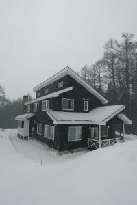 a large house with snow on the side of it at Shofusha Lodge Madarao Tangram in Madarao Kogen