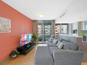 a living room with a couch and a flat screen tv at City 3bd Oasis in Sydney