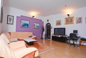 uma sala de estar com um sofá e uma televisão em Epicenter Apartments Split em Split