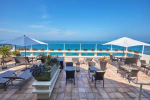 a patio with tables and chairs and a pool at Mercure Granville Le Grand Large in Granville