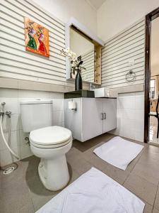 y baño con aseo blanco y lavamanos. en LA CASA BORNEO, en Bentakan Kecil