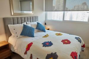 een slaapkamer met een bed met een kleurrijk dekbed bij Amplio y Comodo Depto 2D2B En Santiago Centro in Santiago