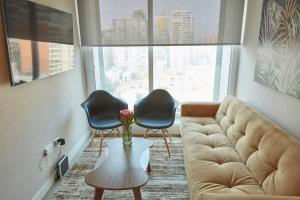 een woonkamer met een bank en 2 stoelen bij Amplio y Comodo Depto 2D2B En Santiago Centro in Santiago