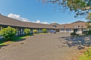 un edificio con un'auto parcheggiata di fronte di Oakwood Manor Motor Lodge ad Auckland