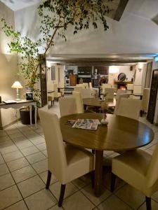 a dining room with a wooden table and chairs at Logis Le Mistral - Montélimar Sud in Châteauneuf-du-Rhône