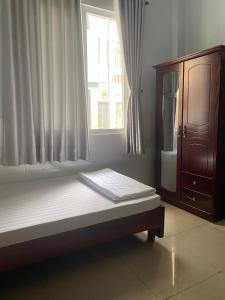 1 cama en una habitación con ventana en Khách sạn Tường Minh, en Cao Lãnh