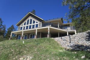a large house on top of a hill at Okanagan Lake Sunrise BB in Vernon