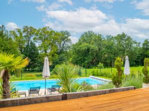 - une piscine dans une cour avec des parasols dans l'établissement Villa Duroux, à Montagrier