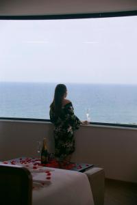 a woman standing in front of a window with wine glasses at PĀMA Boutique Hotel and Bistro in Danang