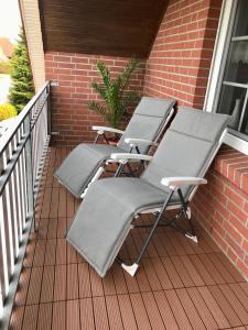 two lounge chairs sitting on a porch at Nordsee-Nest in Ostochtersum